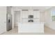 A kitchen featuring stainless steel appliances, quartz countertop island and white cabinetry at 16430 Bird Of Paradise Ave, Clermont, FL 34714