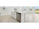 Bright eat-in kitchen island with stainless steel dishwasher, sink and white cabinetry at 16430 Bird Of Paradise Ave, Clermont, FL 34714
