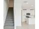 View of the kitchen from the stairs with neutral colors and modern style at 16430 Bird Of Paradise Ave, Clermont, FL 34714
