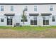 Backyard view of newly built townhomes, with small patios and young trees at 16434 Bird Of Paradise Ave, Clermont, FL 34714