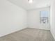 Bright bedroom features neutral carpet, white walls, and natural light from the window at 16434 Bird Of Paradise Ave, Clermont, FL 34714