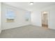 Bright bedroom features neutral carpet, white walls, two windows, and an attached bathroom at 16434 Bird Of Paradise Ave, Clermont, FL 34714