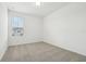Bright bedroom features neutral carpet, white walls, and natural light from the window at 16434 Bird Of Paradise Ave, Clermont, FL 34714