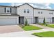 Row of new construction townhouses with manicured lawns, brick paved driveways, and gray exterior paint at 16434 Bird Of Paradise Ave, Clermont, FL 34714