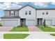 Charming exterior view of a newly built townhouse with light gray siding and a well-manicured front lawn at 16434 Bird Of Paradise Ave, Clermont, FL 34714