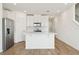 Contemporary kitchen boasts sleek white cabinetry, stainless steel appliances, and a large island, ideal for modern living at 16434 Bird Of Paradise Ave, Clermont, FL 34714