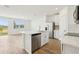 Modern kitchen with white cabinetry, stainless steel appliances, a center island, and wood-look tile flooring at 16434 Bird Of Paradise Ave, Clermont, FL 34714