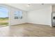Bright living room featuring wood tile floors, a sliding glass door, and a large window for natural light at 16434 Bird Of Paradise Ave, Clermont, FL 34714