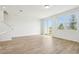 Open living area with wood-look tile flooring, a large window, and a sliding glass door to the patio at 16434 Bird Of Paradise Ave, Clermont, FL 34714