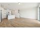 Bright and open living area featuring wood-look tile flooring, kitchen with white cabinets, and staircase at 16434 Bird Of Paradise Ave, Clermont, FL 34714