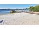 Sandy community beach featuring a wooden pier and calm lake water, ideal for relaxation at 2446 Sweetwater Country Club Dr, Apopka, FL 32712