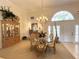 Elegant dining area featuring a chandelier, a china cabinet, and transom windows for natural light at 2446 Sweetwater Country Club Dr, Apopka, FL 32712