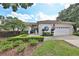 Charming one-story home featuring a tile roof, manicured landscaping, and a two-car garage at 2446 Sweetwater Country Club Dr, Apopka, FL 32712