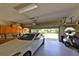 Spacious garage featuring storage cabinets, an automobile, and golf cart, with a partially open door at 2446 Sweetwater Country Club Dr, Apopka, FL 32712