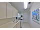 Functional laundry room with sink, cabinets, and washer and dryer at 2446 Sweetwater Country Club Dr, Apopka, FL 32712