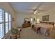 Bright bedroom with neutral tones, shutters, ceiling fan, comfortable bed, and ensuite bathroom at 2446 Sweetwater Country Club Dr, Apopka, FL 32712