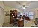 Well-appointed home office with built-in shelving, a classic desk, comfortable seating, and ample natural light at 2446 Sweetwater Country Club Dr, Apopka, FL 32712