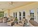 Relaxing screened patio offering comfortable seating, ceiling fans, and views of the lush backyard at 2446 Sweetwater Country Club Dr, Apopka, FL 32712