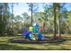 Community playground with colorful play structure in mulched area, surrounded by trees at 2446 Sweetwater Country Club Dr, Apopka, FL 32712
