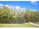 Scenic view of the pond surrounded by lush trees with a boat launch at 2446 Sweetwater Country Club Dr, Apopka, FL 32712