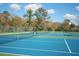 Community tennis court with a well-maintained surface and surrounding greenery, enhancing recreational appeal at 2446 Sweetwater Country Club Dr, Apopka, FL 32712