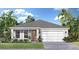 Charming single-story home with a two-car garage, complemented by tropical landscaping and a well-manicured lawn at 30338 Emerald Forest Dr, Mount Dora, FL 32757