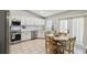 Bright kitchen with white cabinets, stainless steel appliances, tiled backsplash, and a cozy dining area at 360 Coventry Estate Blvd, Deltona, FL 32725
