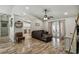 Inviting living room with wood-look floors, ceiling fan, open layout, and views of kitchen and backyard at 360 Coventry Estate Blvd, Deltona, FL 32725