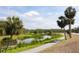 Scenic view of a picturesque pond surrounded by lush greenery and tall palm trees on a walking path at 607 Ross St, Leesburg, FL 34748