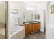 Bathroom with a jacuzzi tub, double vanity sink, and hardwood floors at 829 Terranova Rd, Winter Haven, FL 33884