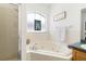 Bright bathroom features soaking tub with decorative window and glass enclosed shower at 829 Terranova Rd, Winter Haven, FL 33884