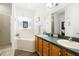 Bright bathroom features double sink vanity, soaking tub with decorative window, and glass enclosed shower at 829 Terranova Rd, Winter Haven, FL 33884