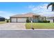 Charming single-story home with a well-manicured lawn, three-car garage, and welcoming entryway at 829 Terranova Rd, Winter Haven, FL 33884