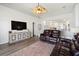 Spacious living room with a ceiling fan, hardwood floors, and a dark-colored leather sofa at 829 Terranova Rd, Winter Haven, FL 33884