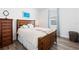 Bedroom with hardwood floors features a large bed and a window with natural light at 829 Terranova Rd, Winter Haven, FL 33884