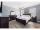 Bedroom with a dark wood dresser and bed frame, wood-style flooring, and two windows with natural lighting at 829 Terranova Rd, Winter Haven, FL 33884