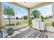 Enclosed patio with a view of the fenced in back yard with tropical plants and grill at 829 Terranova Rd, Winter Haven, FL 33884