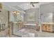 Luxurious bathroom featuring double sinks, a glass-enclosed shower, and a soaking tub at 8740 Ingleton Ct, Orlando, FL 32836