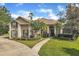 Charming stucco two-story home with a well-manicured lawn and mature landscaping under a bright blue sky at 8740 Ingleton Ct, Orlando, FL 32836