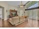 Bright living room featuring hardwood floors, a ceiling fan, and large windows at 8740 Ingleton Ct, Orlando, FL 32836