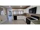 Updated kitchen with white cabinets, granite countertops, black appliances, and tile floors creating a modern space at 10025 Chesham Dr, Orlando, FL 32817