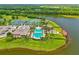 Aerial view showcases community pool, clubhouse, tennis courts, parking, and lake at 1091 Hampstead Ln, Ormond Beach, FL 32174