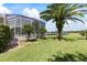 Well-manicured backyard featuring a screened-in pool area and view of the golf course and lake at 1091 Hampstead Ln, Ormond Beach, FL 32174