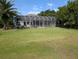 Wide backyard features a screened-in lanai, palm trees, and scenic views at 1091 Hampstead Ln, Ormond Beach, FL 32174