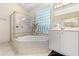 Bright bathroom features a glass enclosed shower and tiled soaking tub at 1091 Hampstead Ln, Ormond Beach, FL 32174