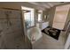 Bright bathroom featuring a shower, soaking tub, and vanity with a glass block window at 1091 Hampstead Ln, Ormond Beach, FL 32174