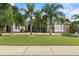 Charming, stone-accented home featuring a meticulously maintained lawn and mature palm trees at 1091 Hampstead Ln, Ormond Beach, FL 32174