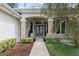 Inviting front entrance features stone columns, glass-paneled doors, and professionally landscaped flowerbeds at 1091 Hampstead Ln, Ormond Beach, FL 32174