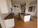 Bright kitchen featuring granite counters, white cabinetry and hardwood flooring at 1091 Hampstead Ln, Ormond Beach, FL 32174