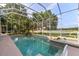 Beautiful covered pool and jacuzzi with waterfall feature and relaxing view of lake at 1091 Hampstead Ln, Ormond Beach, FL 32174